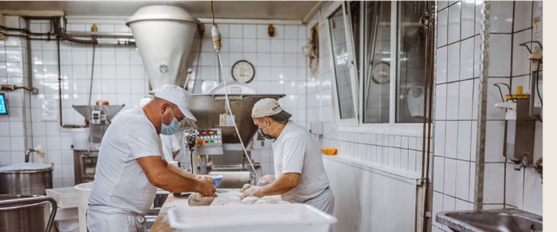 Zwei Bäcker bei der Handarbeit in der Backstube